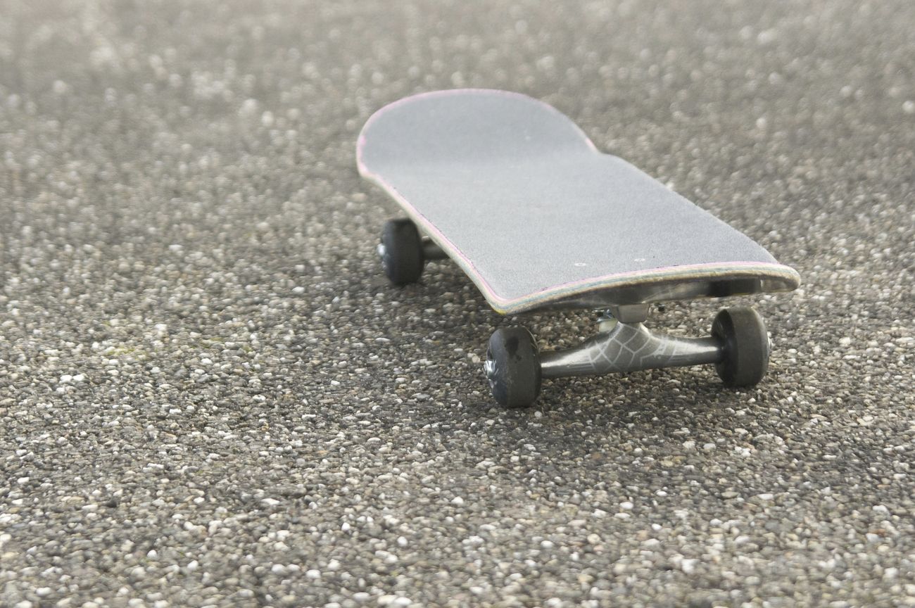 Closeup of skateboard on asphalt